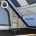 Image of the interior of an Overland Vehicle Systems tent, showcasing overhead storage options with mesh pockets and beige fabric compartments. The tent also features 2.25" high density foam mattress and two built-in storage options on each side
