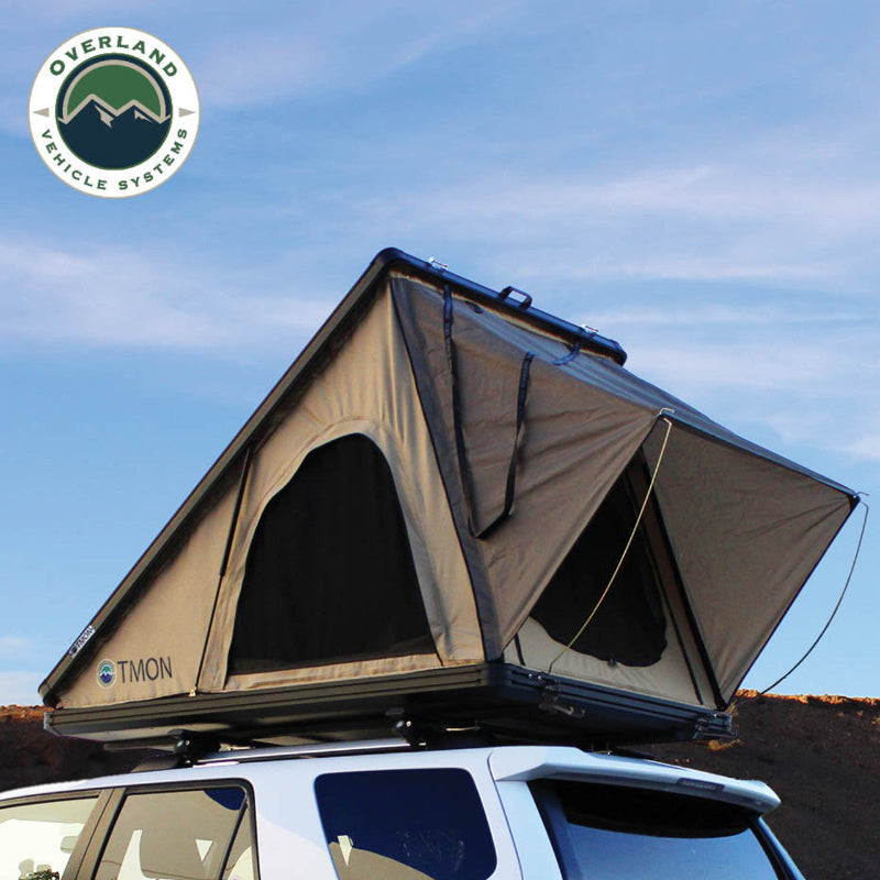 Image showcasing a double-insulated one-piece black diamond plate base, along with heavy-duty ballistic nylon tent closure straps for an Overland Vehicle Systems tent. The base has a textured, metallic appearance, and the strap is visible securing a tent component