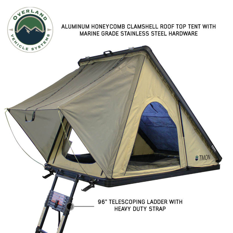 Image displaying an olive green Overland Vehicle Systems roof top tent, fully deployed on top of a white SUV against a desert landscape, ready for outdoor adventure. The tent has a "TMON" logo on its side