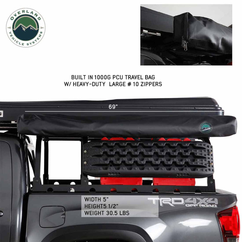 Image of a black travel bag for an awning, showcasing heavy-duty zippers, mounted on the side of a gray pickup truck bed, with text overlays of "69"", "WIDTH 5"", "HEIGHT 5 1/2"", and "WEIGHT 30.5 LBS".