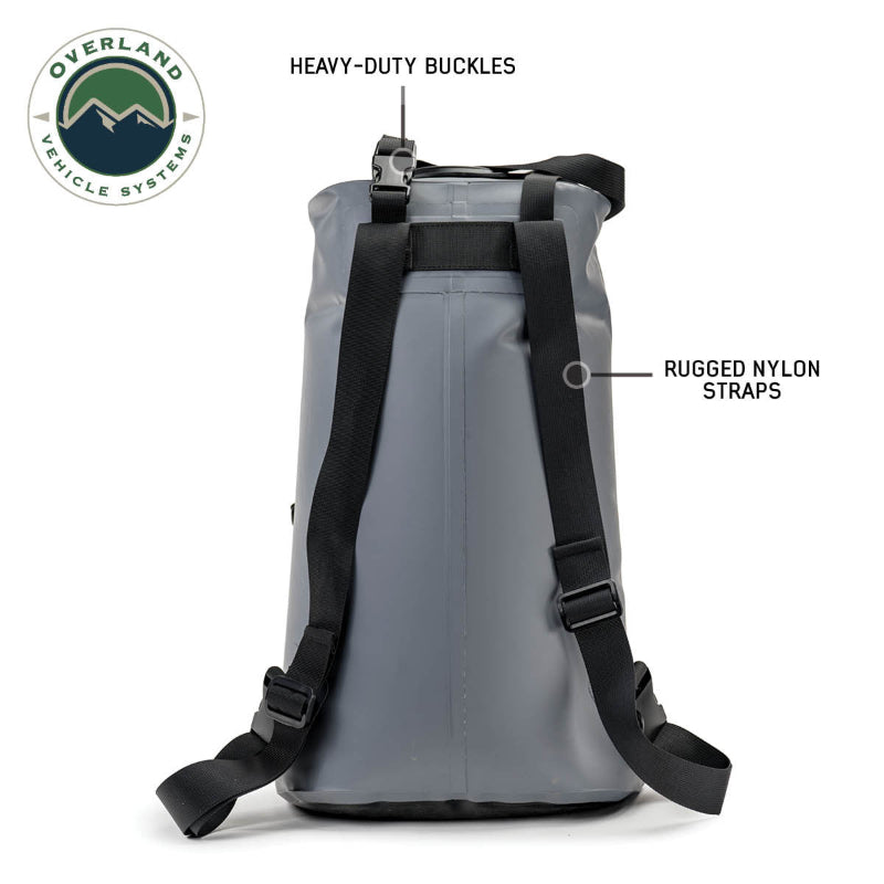 Image of Overland Vehicle Systems portable camp shower bag showing rear view with rugged nylon shoulder straps and heavy-duty buckles, gray roll-top waterproof design on white background