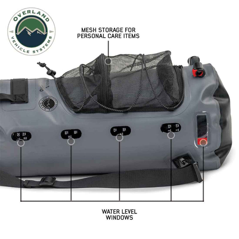 Image of Overland Vehicle Systems portable camp shower bag laid horizontally showing mesh storage pocket and integrated water level windows, gray waterproof design with straps on white background