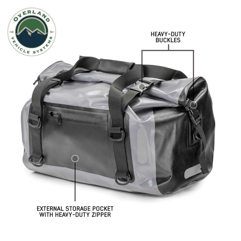 Image of a gray and black Overland Vehicle Systems IPX6 waterproof duffel bag, highlighting its heavy-duty buckles and external storage pocket with a heavy-duty zipper.