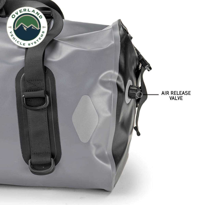 Image of a gray and black Overland Vehicle Systems IPX6 waterproof duffel bag, showing a close-up of its air release valve on the side.