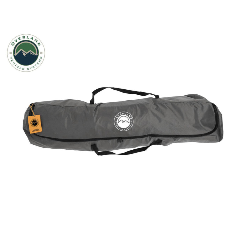 Image of a portable privacy shower tent carry bag with zippered closure and handles, dark gray fabric with logo, straight side view on white background.