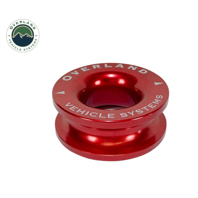 Image of Overland Vehicle Systems recovery ring made from red anodized aluminum with engraved branding, compact recovery hardware shown in angled front view on white background.