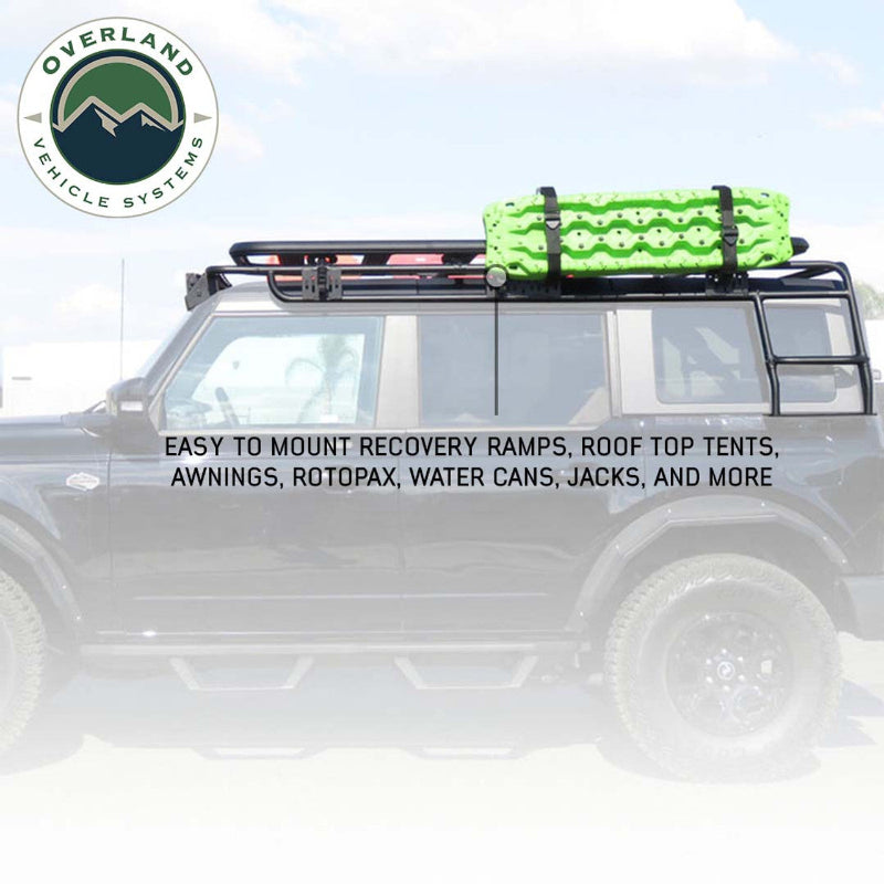 Image of a black roof rack on a Ford Bronco, with a green recovery ramp mounted on top, highlighting that it can easily mount a variety of accessories like tents, awnings, and water cans