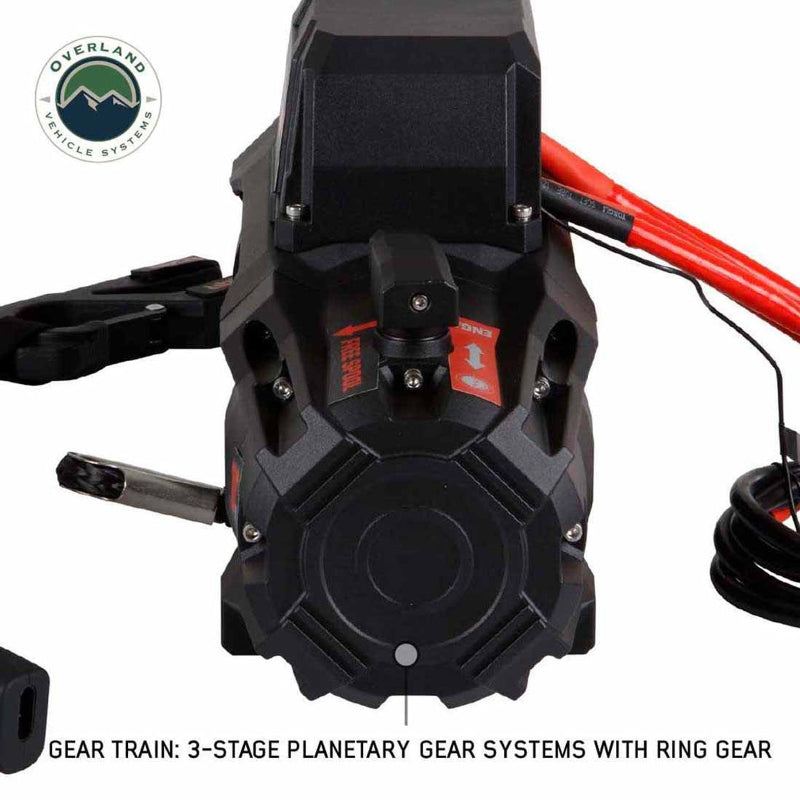 Close-up, detailed view of the gear train end of the Overland Vehicle Systems SCAR Synthetic Rope Winch on a white background. The image focuses on the winch's 3-stage planetary gear system with ring gear