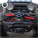 Image of the black Overland Vehicle Systems (OVS) SCAR winch installed on the front bumper of a truck, featuring a red '12p' and a shackle block for heavy-duty pulling. The truck has large, round spotlights and is ready for off-road use