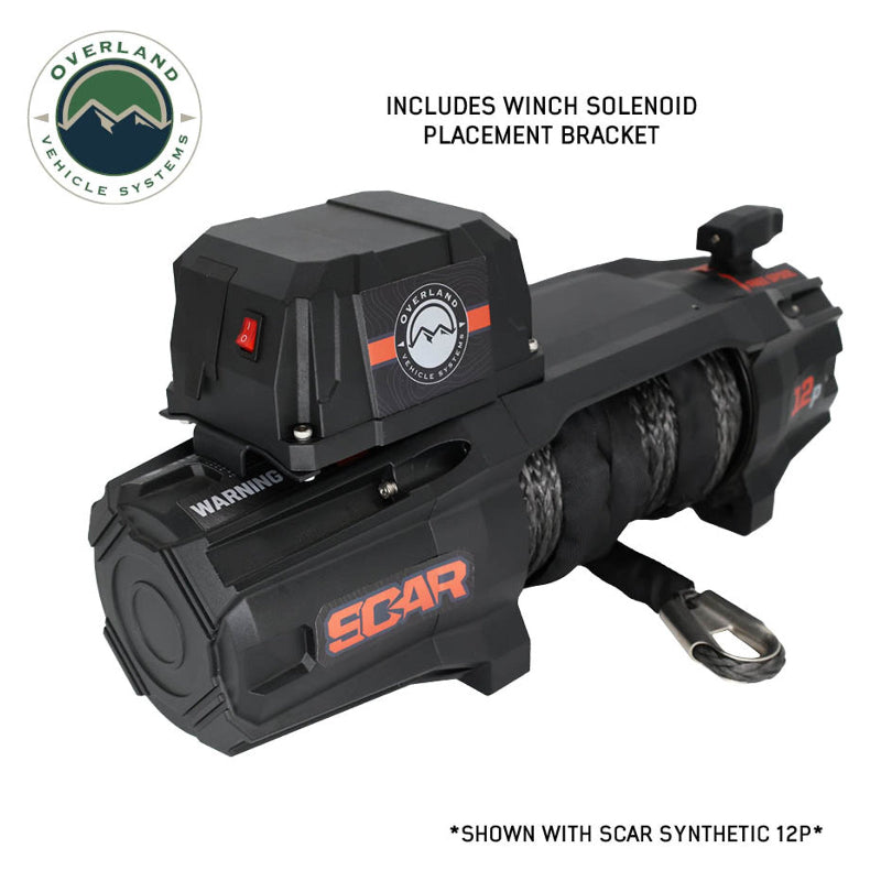 Image of the black Overland Vehicle Systems (OVS) SCAR winch, angled to show the solenoid placement bracket with a red power switch on top. The winch features a red '12p' and 'SCAR' text, on a white background