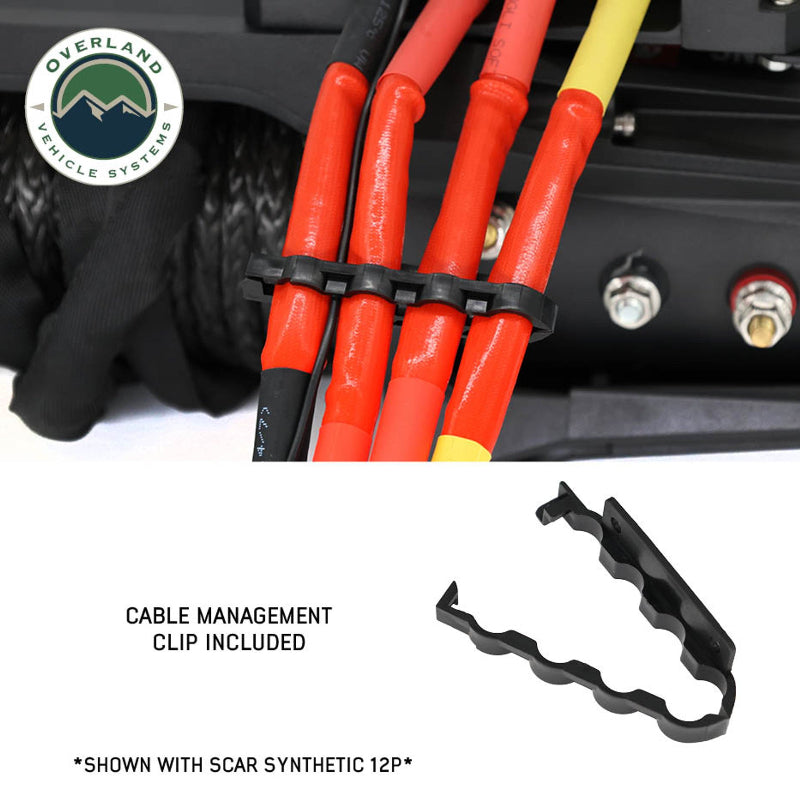 Image of a close-up on the black Overland Vehicle Systems (OVS) SCAR winch's electrical connections, showing red and yellow wires neatly organized by the included cable management clip. An inset image shows a separate view of the black clip itself