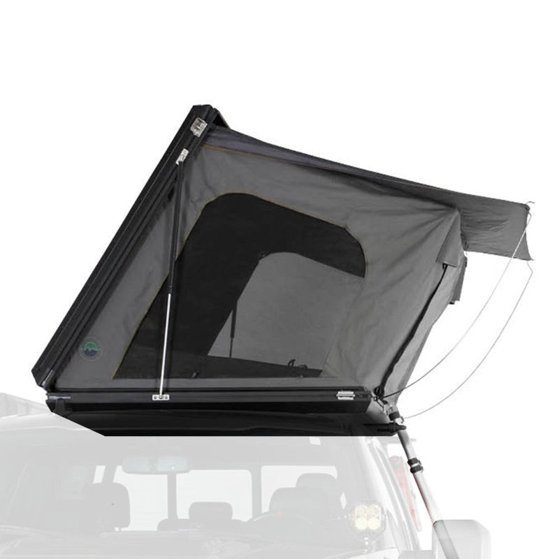 Image of a dark grey hardshell rooftop tent, partially open and set up on top of a vehicle, with a small awning extended to the side. The tent features a large window opening and appears ready for camping