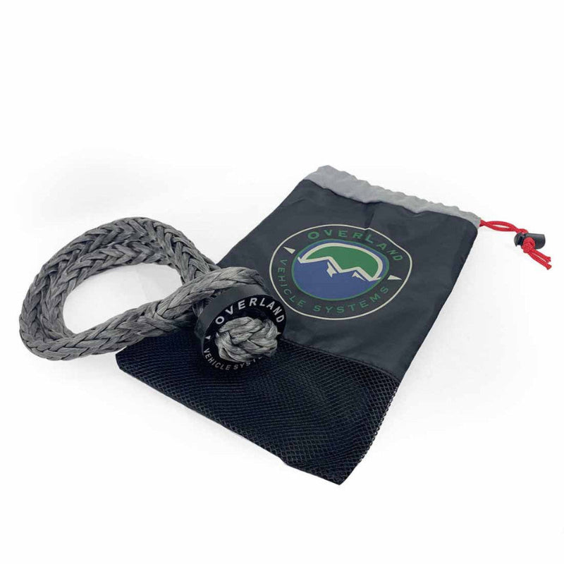 Image of Overland Vehicle Systems soft shackle recovery rope coiled with protective sleeve and branded storage pouch, gray braided synthetic rope with black and green logo, front angled view on white background.