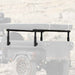 Image of a black OVS Overland Vehicle Systems Freedom Rack cargo carrier mounted on the back of an off-road trailer, shown against a blurred outdoor background