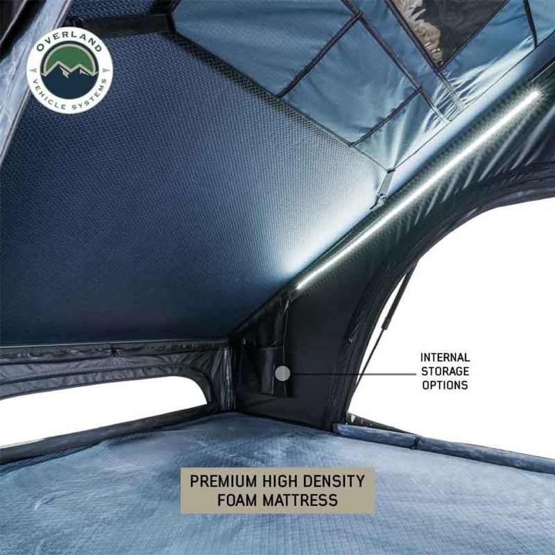 Image of Overland Vehicle Systems rooftop tent interior featuring a premium high-density foam mattress, internal storage options, and LED lighting along the base, with blue fabric walls