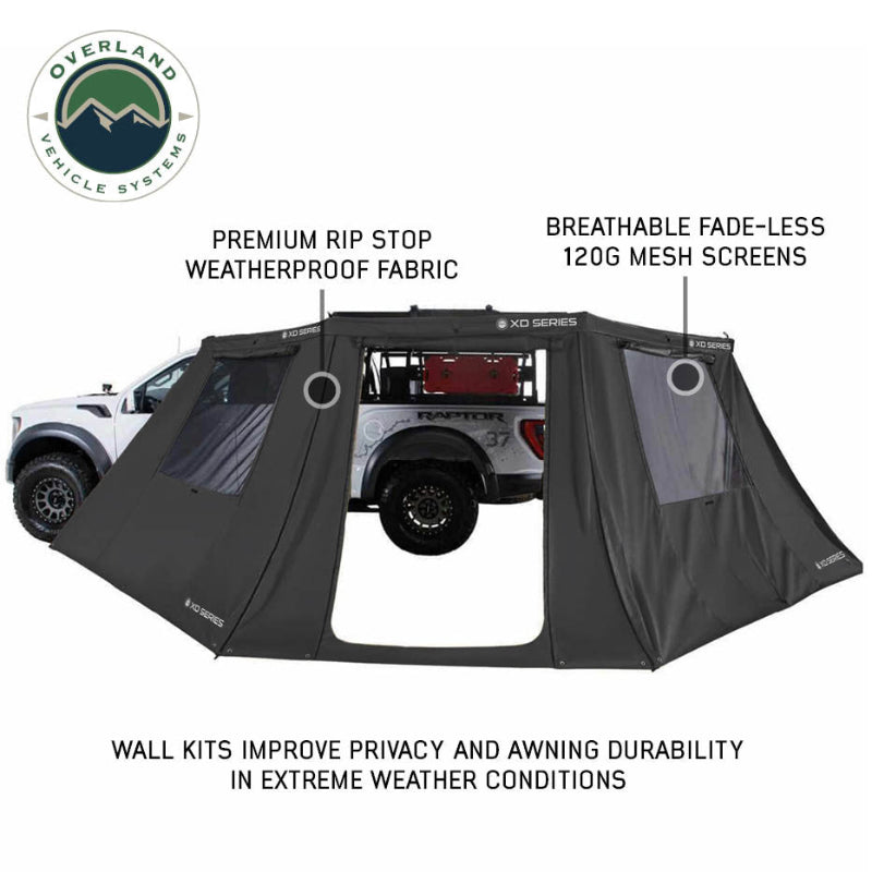 Image of OVS XD Nomadic 180 LTE awning walls installed around a pickup truck, black ripstop fabric with mesh window panels and feature callouts, shown in side view on a white background.