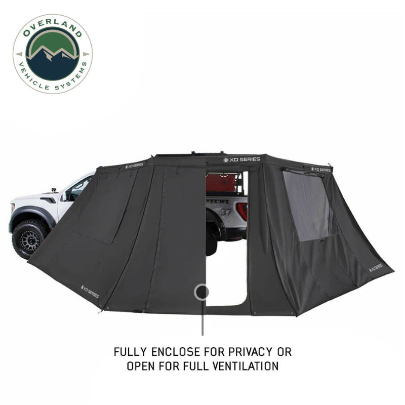Image of OVS XD Nomadic 180 LTE awning walls shown half enclosed and half open, black fabric with mesh window panel demonstrating privacy and ventilation, side view on a white background.