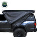 Image showcasing built-in gaze-less and fade-less screen windows on a black Overland Vehicle Systems awning, with a dark interior visible through the mesh. The awning is partially deployed, showing its support structure