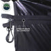 Image showcasing a black Overland Vehicle Systems 270-degree awning partially deployed from the side of a dark grey pickup truck, illustrating how the awning is stored and deployed. The awning fabric is folded and secured against the truck, indicating a travel position