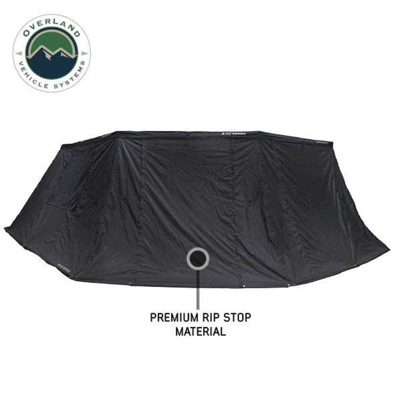Image showcasing a black 270-degree awning with premium rip stop material, fully extended and seen from a front-angled view against a white background. The "Overland Vehicle Systems" logo is in the top left corner