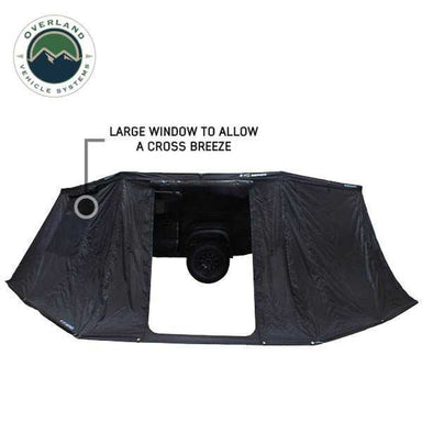 Image of an olive green Overland Vehicle Systems Nomadic roof top tent, fully deployed with a completely removable rainfly and 120G fade-less glaze breathable windows. The tent's body is made from 280G poly cotton double rip stop material, all set against a white background