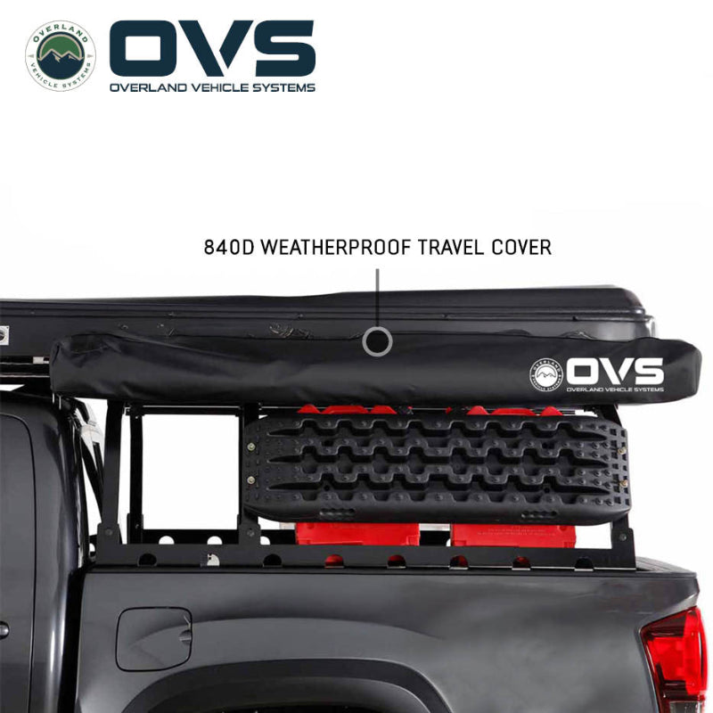 Image of an OVS XD Nomadic 270 LTE awning stored in its black 840D waterproof travel cover mounted on a pickup truck rack, shown in side view on a white background.