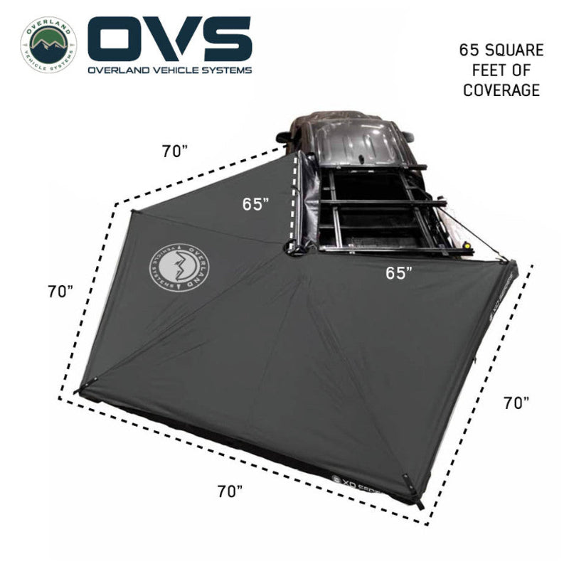 Image of an OVS XD Nomadic 270 LTE awning deployed from a vehicle roof rack, black fabric showing 65 square feet of coverage with labeled dimensions, displayed in top-down angled view on a white background.
