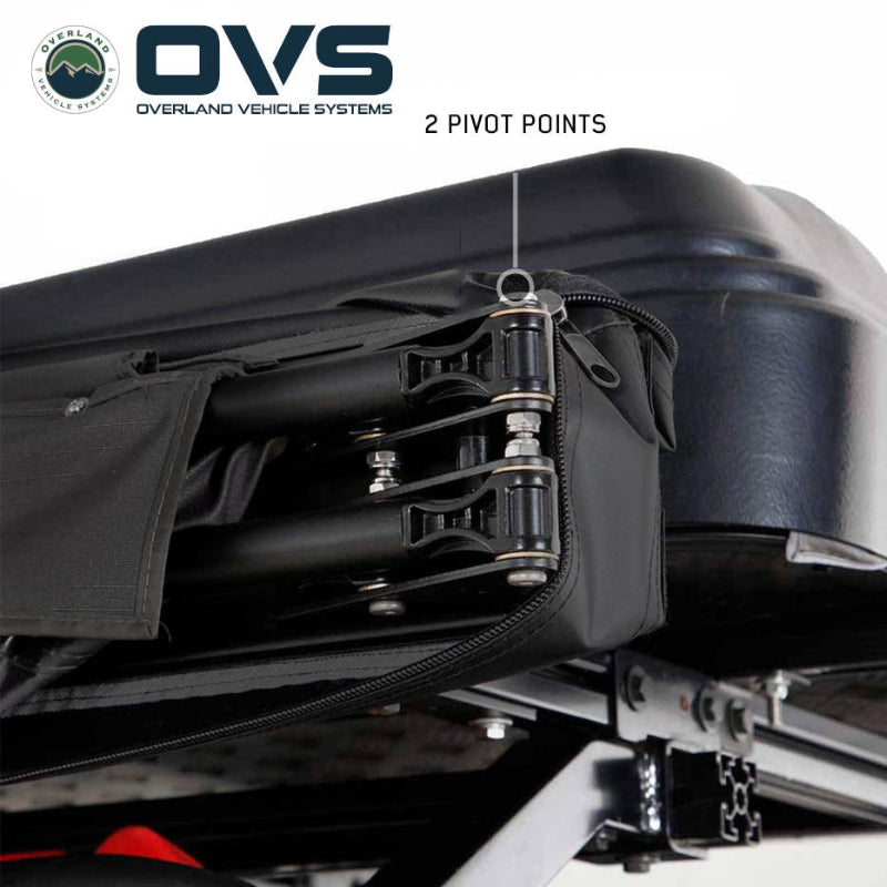 Image of a close-up of an OVS XD Nomadic 270 LTE awning hinge assembly showing dual pivot points and reinforced hardware mounted to a roof rack, displayed in detail on a white background.