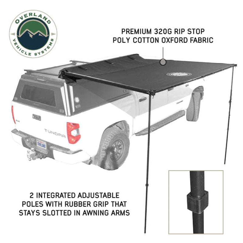 Image of the OVS Nomadic 90 Awning fully deployed on a white truck, black premium 320G ripstop poly cotton oxford fabric, angled rear and side view on a white background, showing the two adjustable support poles
