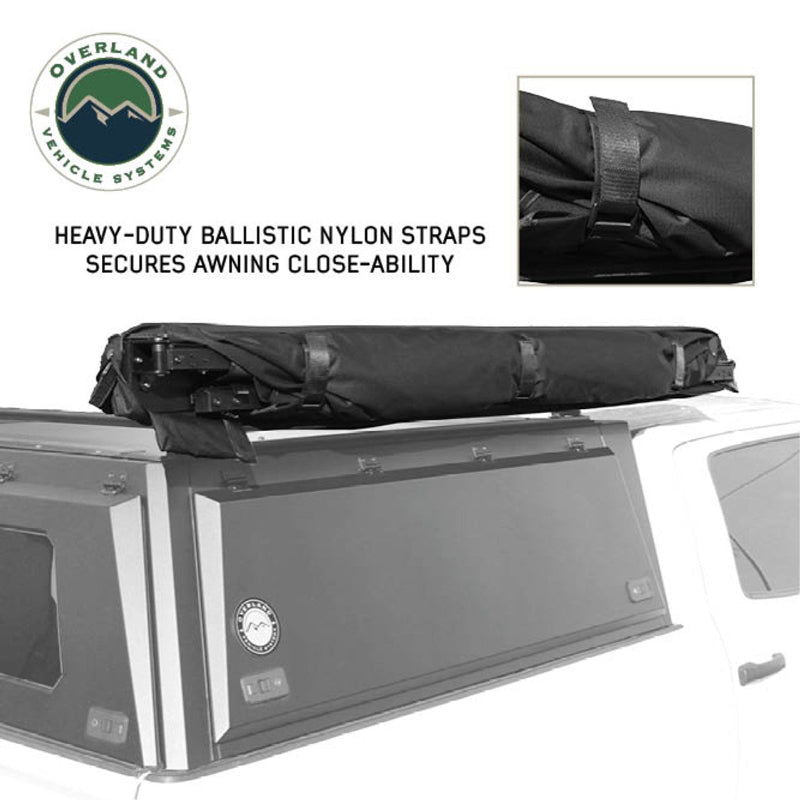 Image of the OVS Nomadic 90 Awning fully deployed on a white truck, black premium 320G ripstop poly cotton oxford fabric, angled rear and side view on a white background, showing the two adjustable support poles