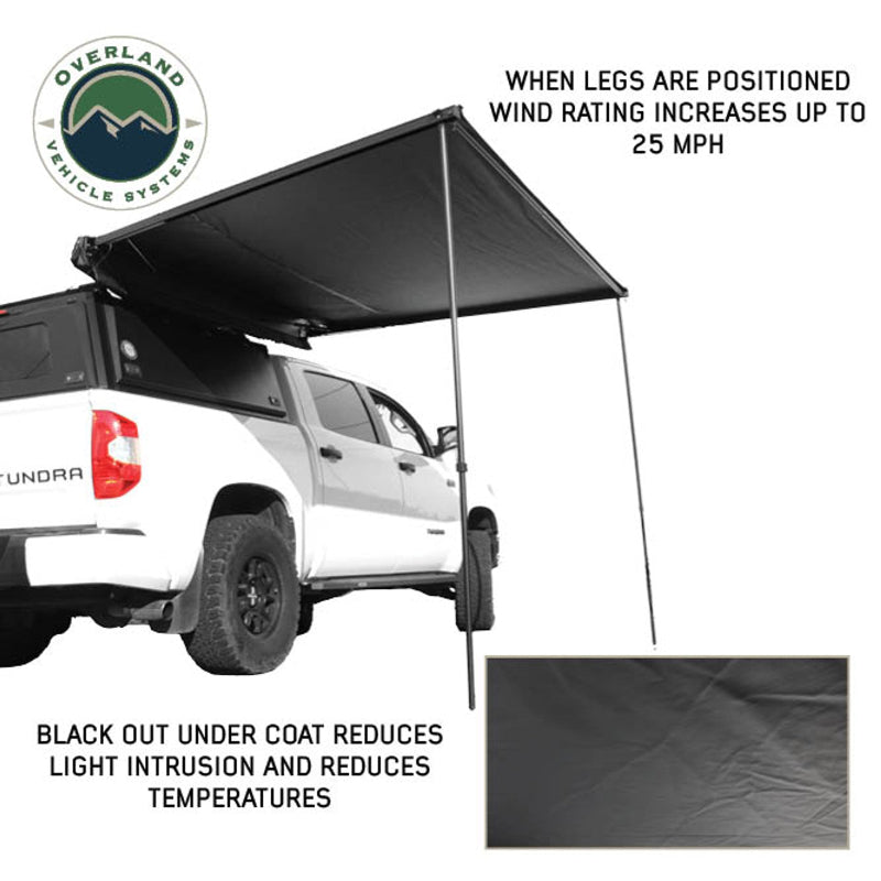 Image of the OVS Nomadic 90 Awning fully deployed from a white truck, featuring black fabric and support poles that increase wind rating. An inset shows the black undercoat designed to reduce light intrusion and temperatures