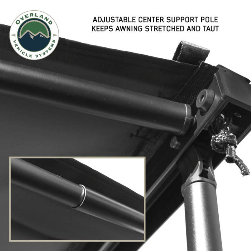 Image of the OVS Nomadic 270 Awning fully deployed on a white van, featuring black fabric with a black underside, and supported by three fixed and three additional telescoping aluminum poles that expand up to 3 meters