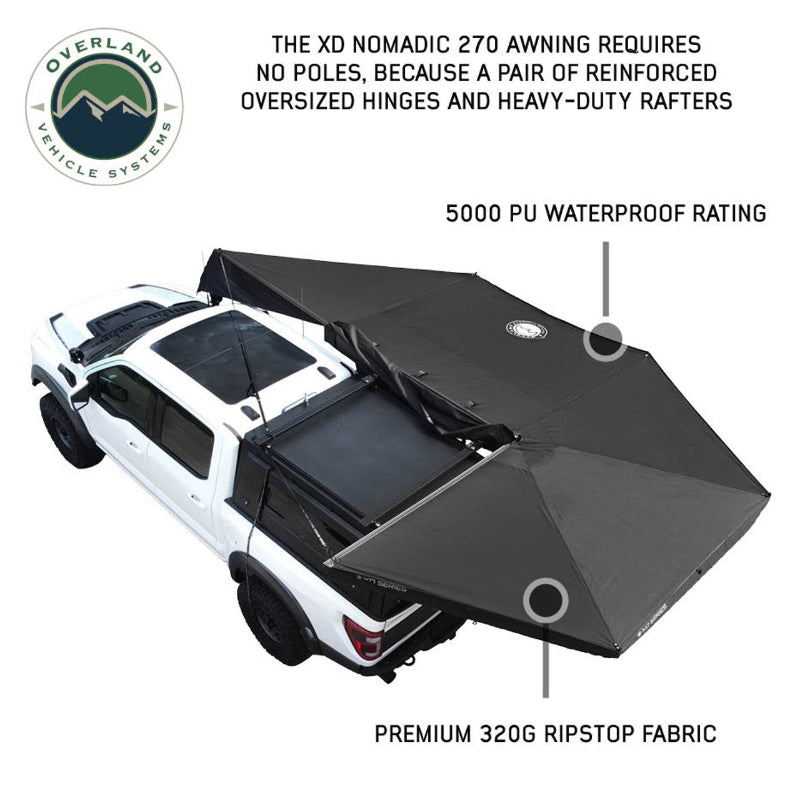 Angled top-down view of a white pickup truck with an OVS Nomadic 270 Awning partially deployed. The black awning extends from the side and rear of the truck, highlighting its poleless design and durable materials, with text annotations pointing to the waterproof rating and ripstop fabric