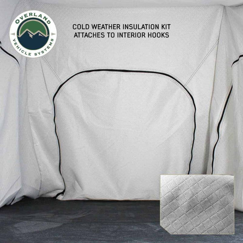 Image displaying the interior of a rooftop tent with a white cold weather insulation kit attached to interior hooks, featuring a quilted texture swatch in the bottom right corner. The "Overland Vehicle Systems" logo is in the top left corner