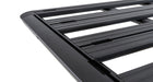 Image of Rhino-Rack roof rack, black aluminum frame with slatted design, close-up angled side view showing grooves and edges on white background