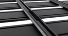 Image of Rhino-Rack roof rack, black aluminum frame with slatted design and white inlays, close-up angled view of the grooves on white background