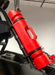 Red RollPaX gasoline container mounted to the side of a vehicle, angled side view.