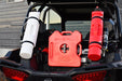 Three Rotopax fuel containers—one white 1.5-gallon, one red 2-gallon, and one red 1.5-gallon—mounted on the rear of an off-road vehicle, showcasing secure storage for extra fuel.
