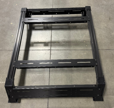 Image of Thors Lightning truck bed rack frame in black powder-coated steel, top-down angled view on concrete floor background.