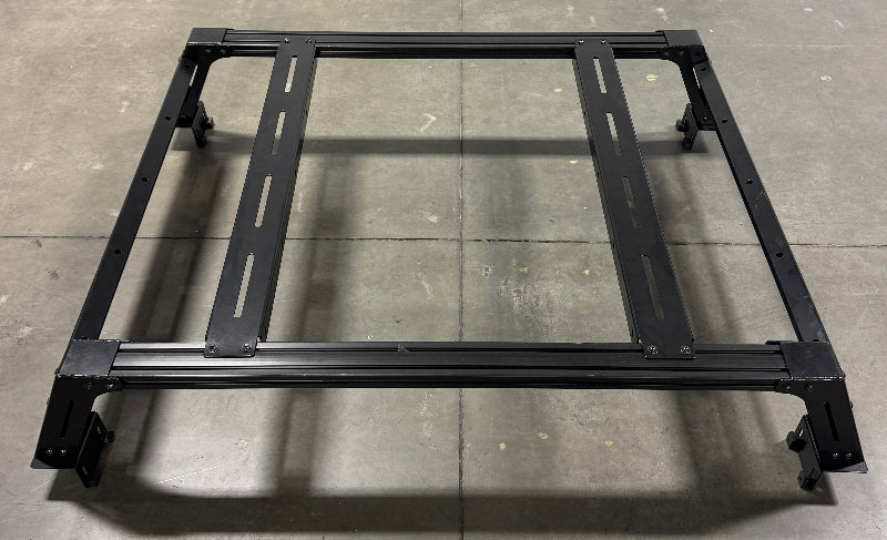 Image of Thors Lightning truck bed rack frame in black powder-coated steel with crossbars, angled top and side view on concrete floor background.