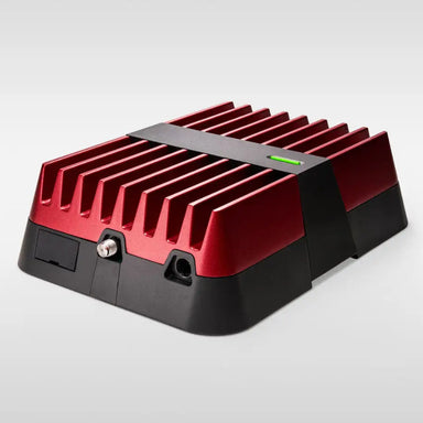 Image of a red and black electronic device, possibly a power inverter or booster, with prominent cooling fins and a green LED indicator light on top, featuring various ports on the front, angled front and side view on a white background