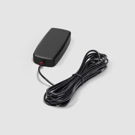 Image of a sleek, black rectangular GPS tracker or antenna with a coiled black cable extending from it, featuring a small red indicator, angled top-down view on a white background
